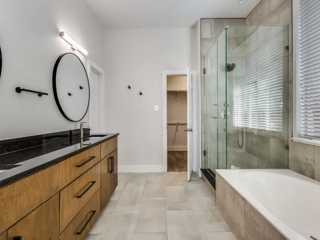 a spacious bathroom with a mirror a bathtub and shower