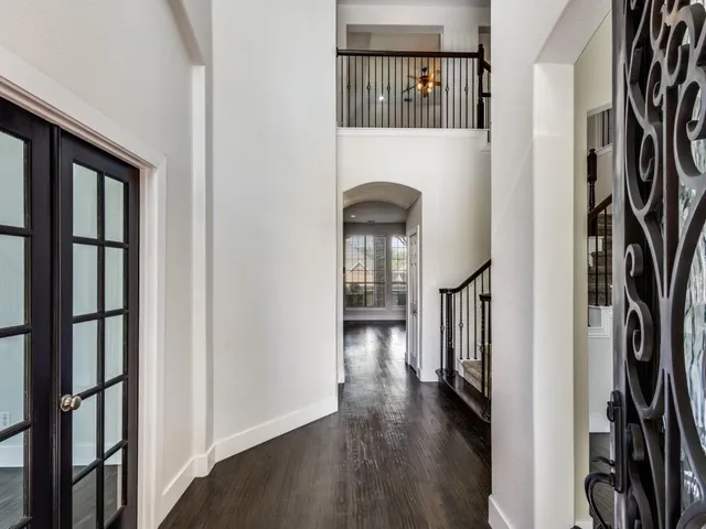 a view of a hallway with wooden floor and entryway