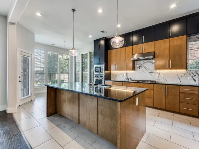 a kitchen with stainless steel appliances granite countertop a sink counter space cabinets and a large window