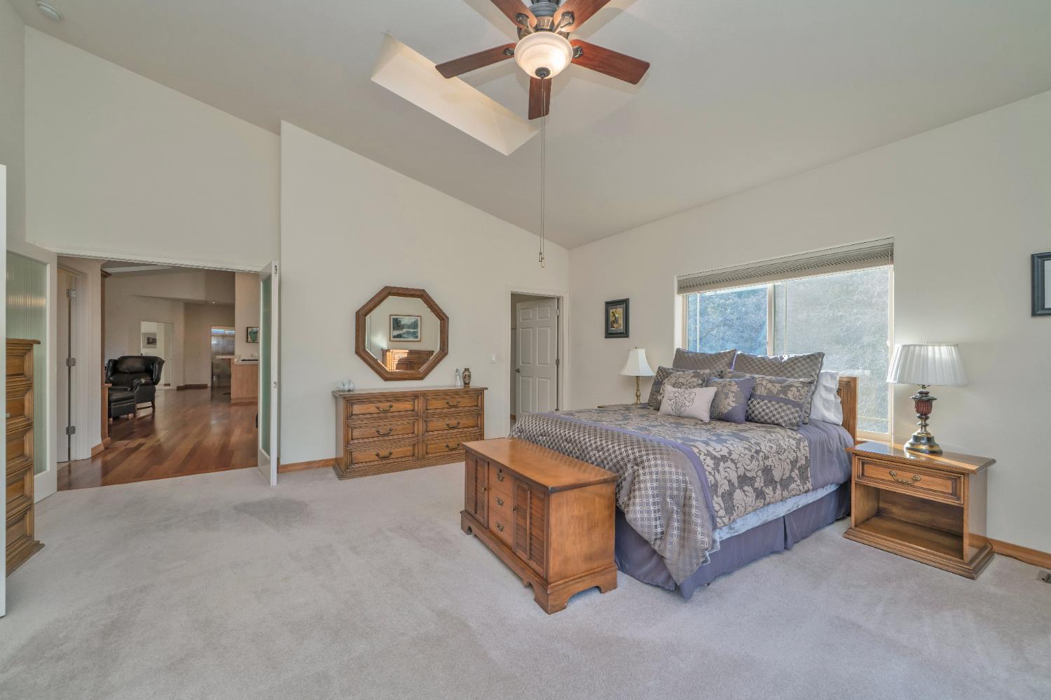 6510 Sly Park Road Placerville, CA 95667 - Photo 22 of 50 a spacious bedroom with a bed a dresser and a chandelier