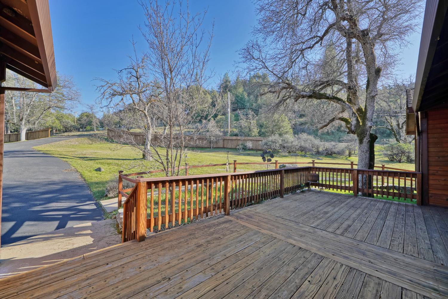 6510 Sly Park Road Placerville, CA 95667 - Photo 8 of 50 a view of a deck with wooden floor and fence next to a yard