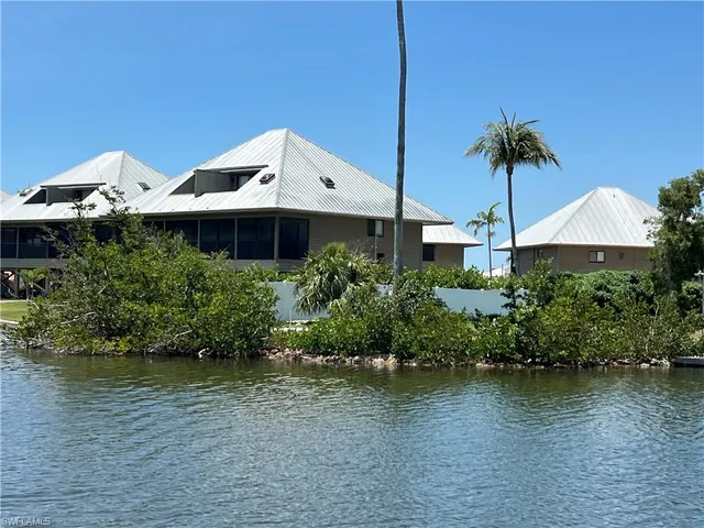 a backyard of a house with plants and lake view
