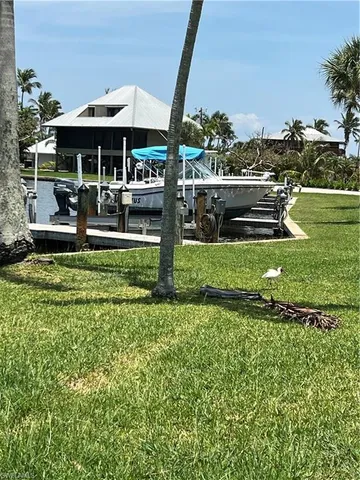 a view of a swimming pool with lawn chairs under an umbrella