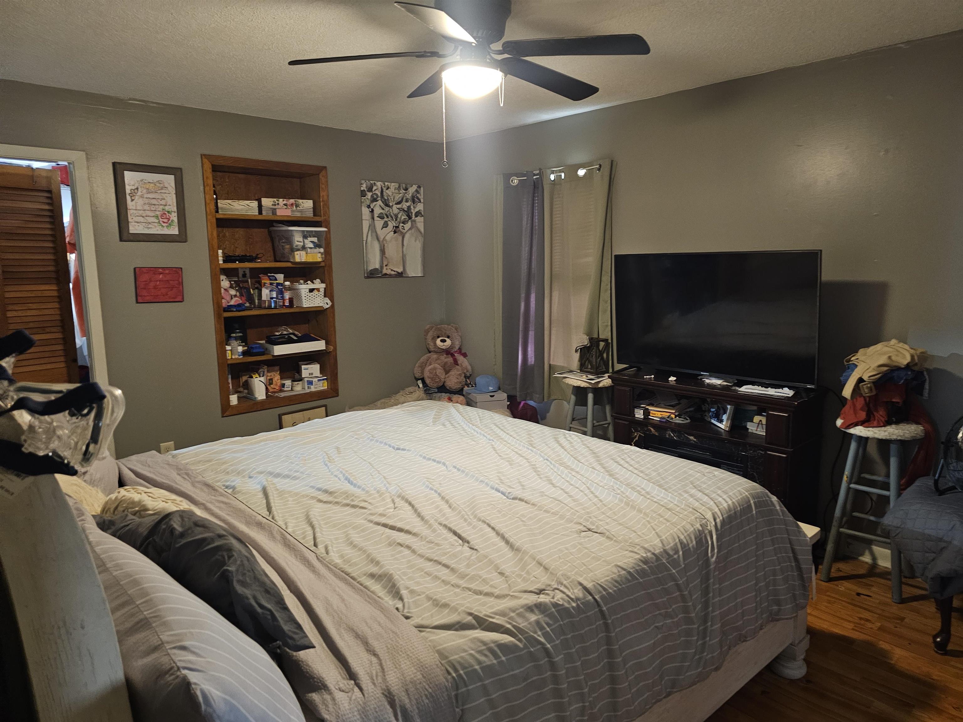 488 Perkins Street Ripley, TN 38063 - Photo 9 of 23 a bedroom with a bed a flat screen tv and a chandelier