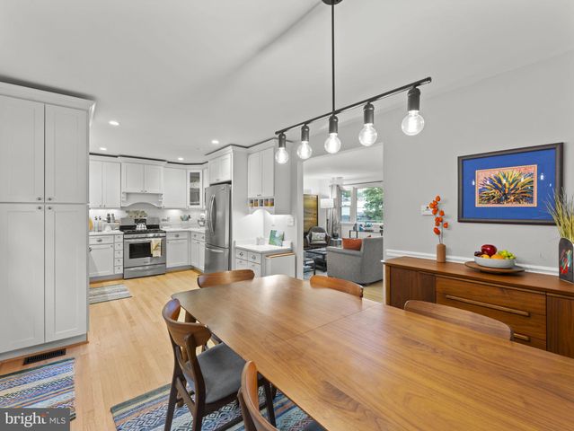 a view of a dining room and livingroom with furniture wooden floor a chandelier