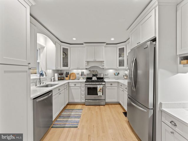 a kitchen with a refrigerator a sink and cabinets