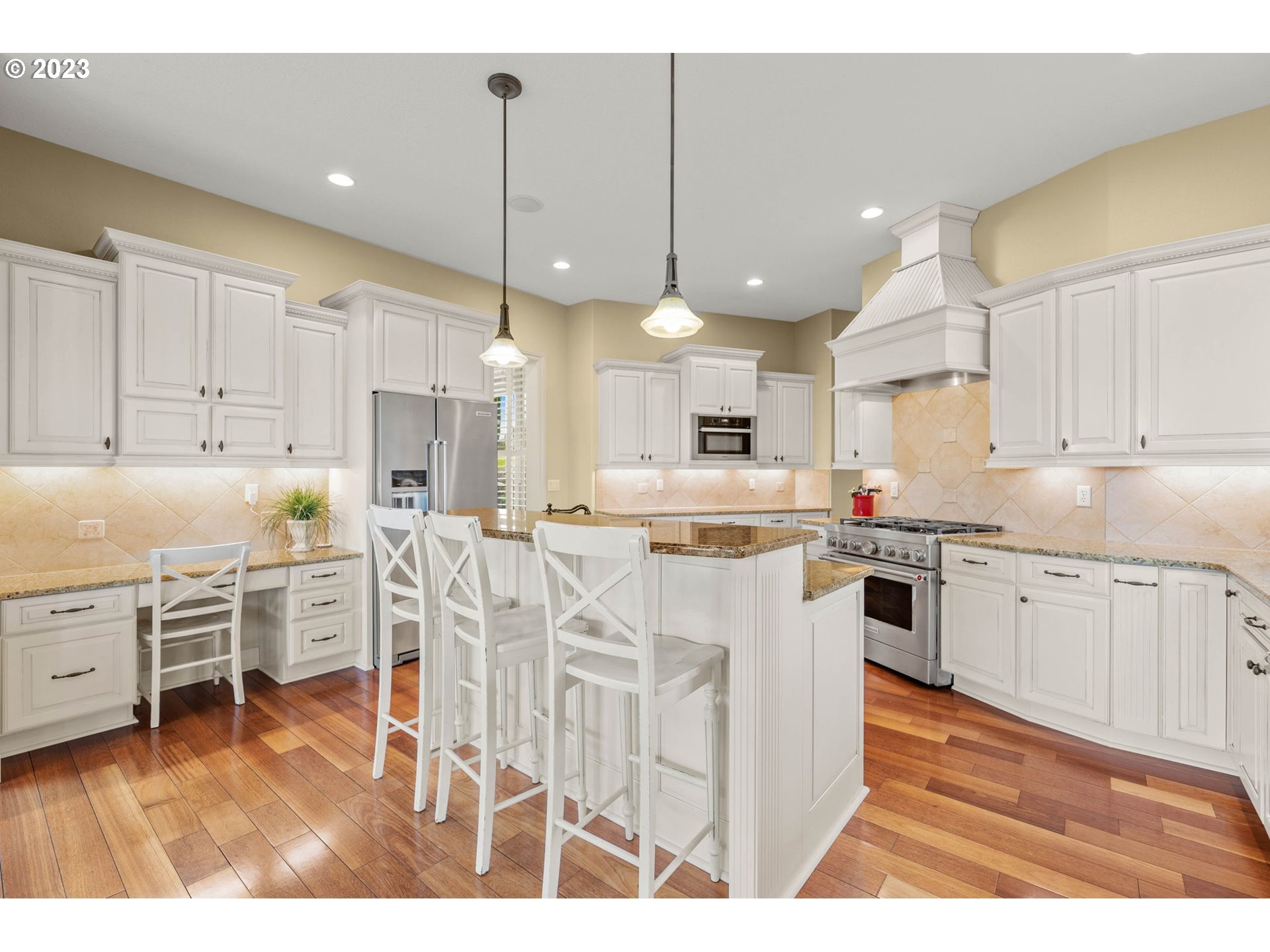 6405 Northwest 202nd Circle Ridgefield, WA 98642 - Photo 22 of 45 a kitchen with white cabinets and chairs