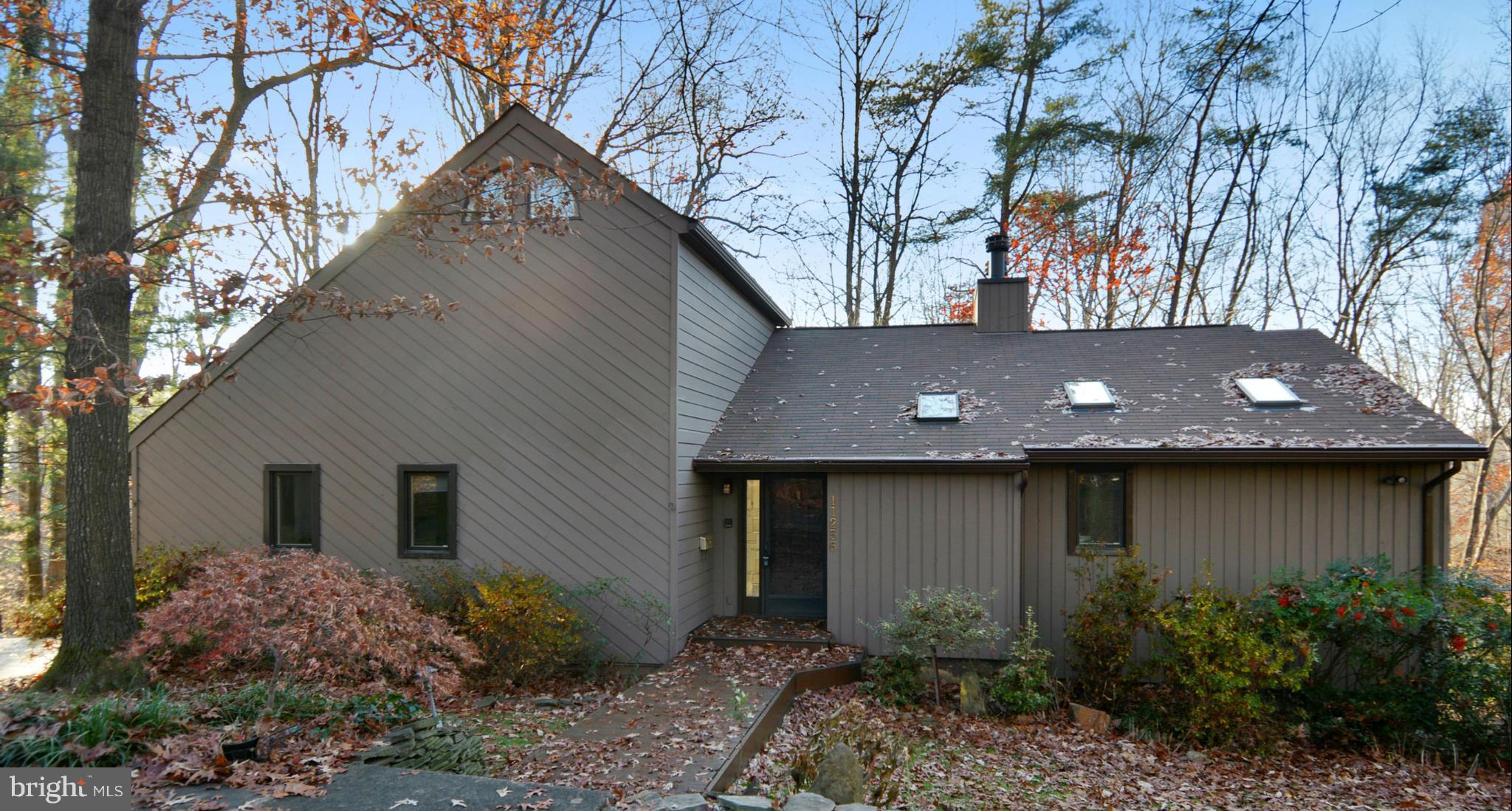 a front view of house with yard and trees around