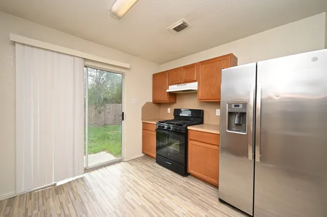 a kitchen with stainless steel appliances granite countertop a refrigerator and a sink