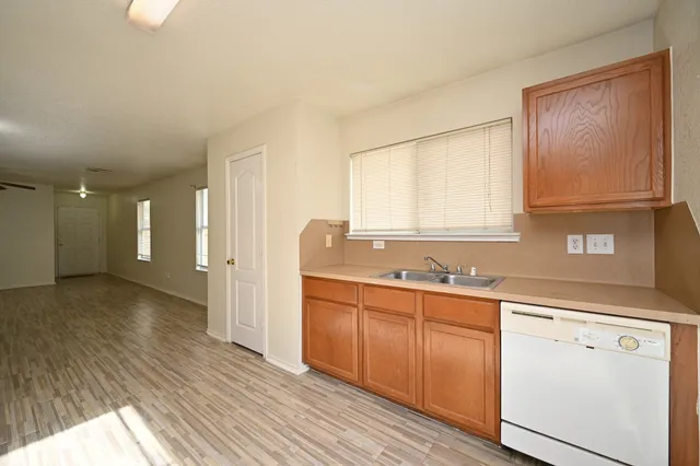 a room with a sink cabinets and wooden floor