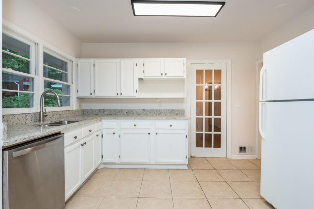 1392 Lively Ridge Road Northeast Atlanta, GA 30329 - Photo 13 of 42 a kitchen with granite countertop a sink and a refrigerator