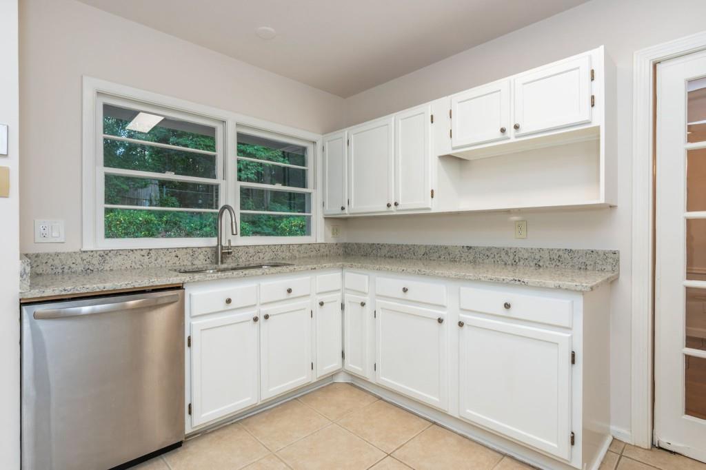 1392 Lively Ridge Road Northeast Atlanta, GA 30329 - Photo 14 of 42 a kitchen with granite countertop white cabinets stainless steel appliances a sink and a window