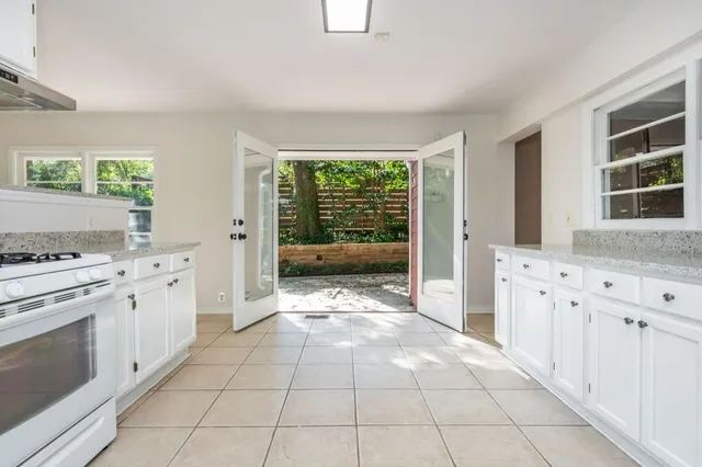 a kitchen with granite countertop a stove a sink and a refrigerator