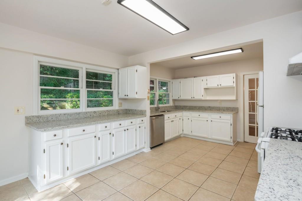 1392 Lively Ridge Road Northeast Atlanta, GA 30329 - Photo 18 of 42 a kitchen with granite countertop white cabinets and white appliances