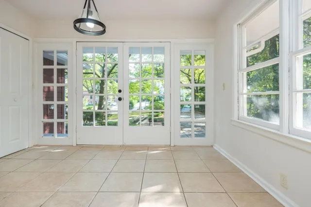 a view of an empty room with windows and chandelier