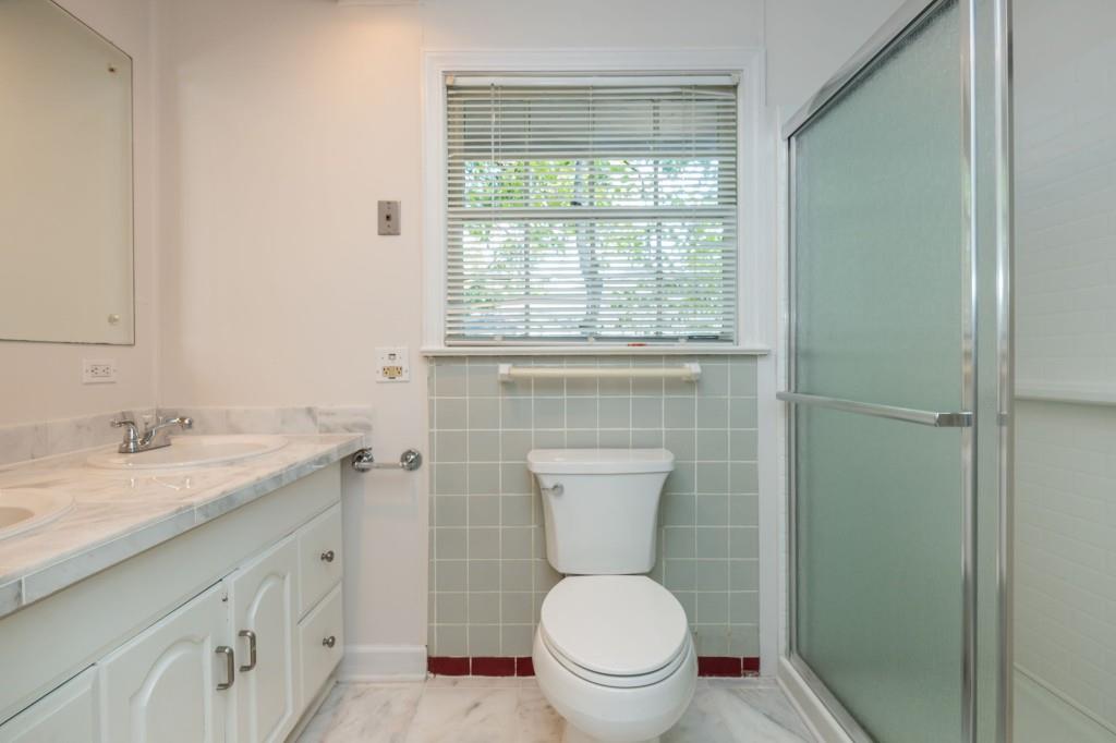 1392 Lively Ridge Road Northeast Atlanta, GA 30329 - Photo 29 of 42 a bathroom with a granite countertop toilet a sink and a window