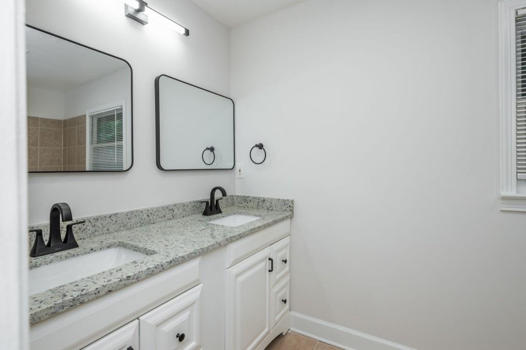 1392 Lively Ridge Road Northeast Atlanta, GA 30329 - Photo 34 of 42 a bathroom with a granite countertop sink and a mirror