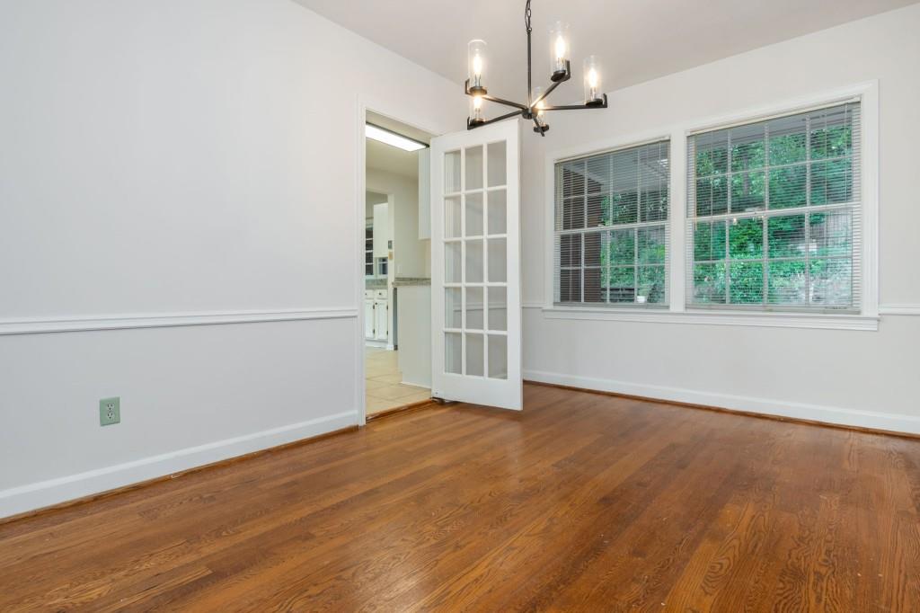 1392 Lively Ridge Road Northeast Atlanta, GA 30329 - Photo 10 of 42 an empty room with wooden floor exposed radiator and windows