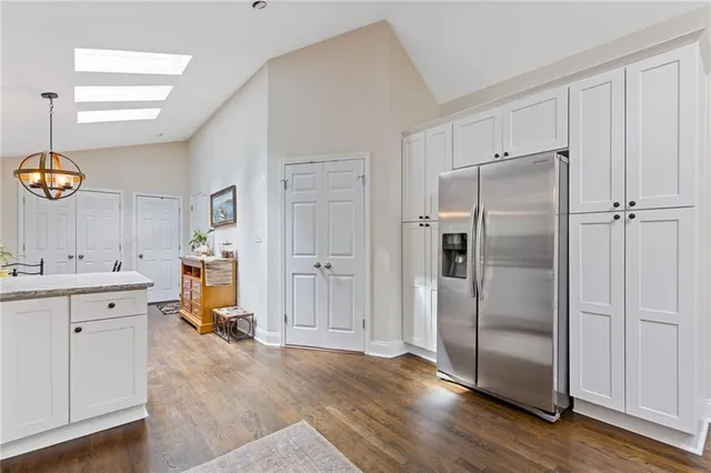 a kitchen with white cabinets and wooden floor