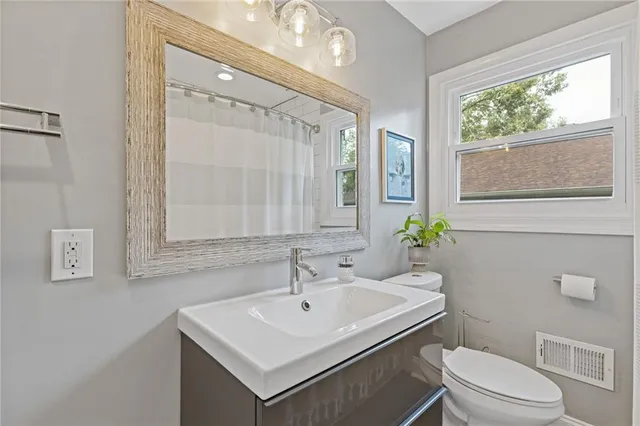 a bathroom with a sink a toilet and a mirror