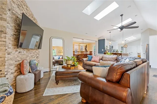 a living room with furniture kitchen view and a flat screen tv