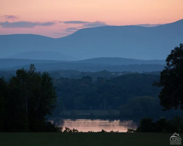 a view of mountain with sunset in background