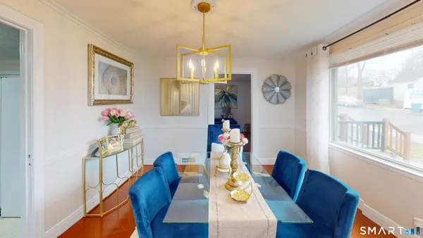 a view of a dining room with furniture a chandelier and wooden floor