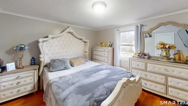 a bedroom with a bed and wooden floor