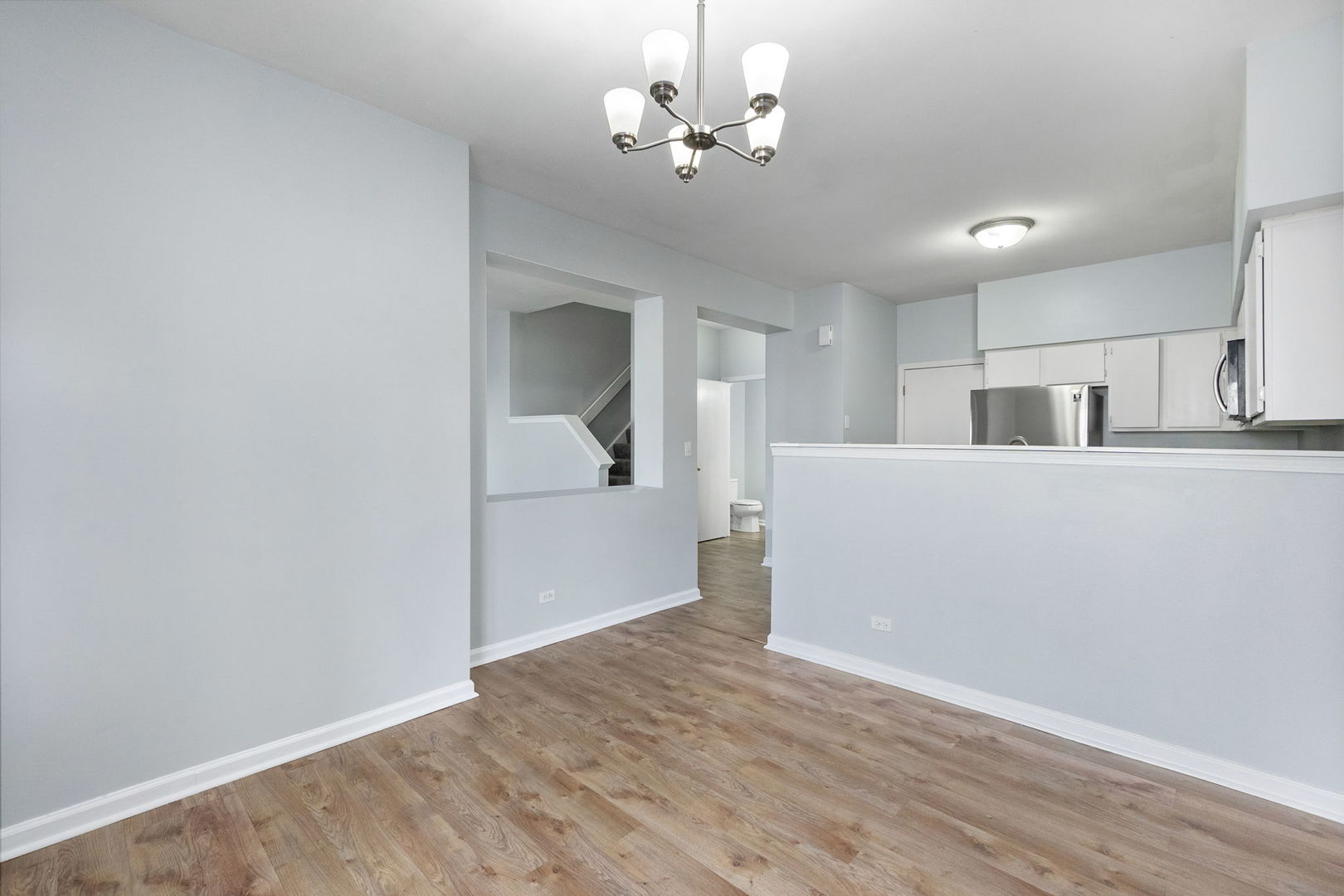 199 North Oakhurst Drive, Unit 199 Aurora, IL 60504 - Photo 13 of 25 a view of a kitchen with wooden floor and a ceiling fan