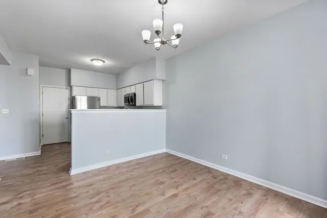 a view of a kitchen with wooden floor and a window