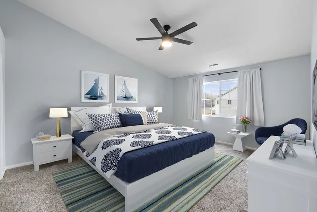 a bedroom with bed a two couches and a window