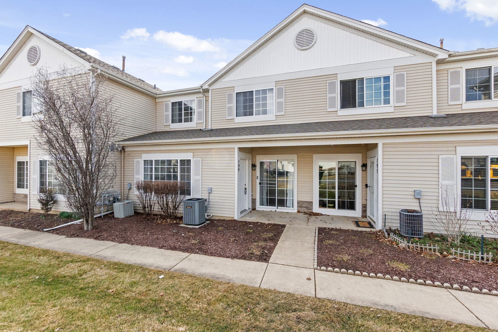 199 North Oakhurst Drive, Unit 199 Aurora, IL 60504 - Photo 2 of 25 a front view of a house with a yard and garage