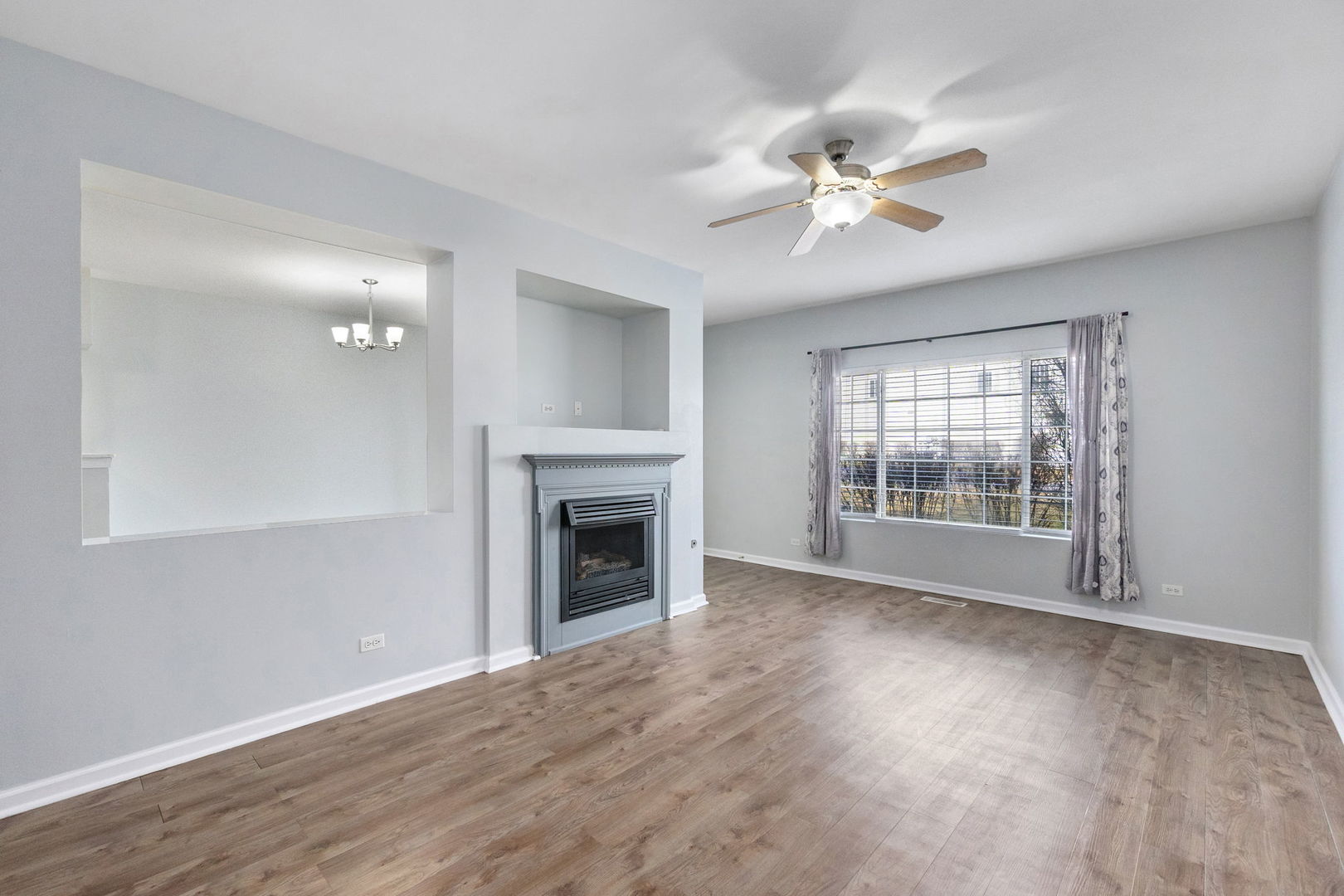 199 North Oakhurst Drive, Unit 199 Aurora, IL 60504 - Photo 7 of 25 a view of an empty room with a fireplace and a window