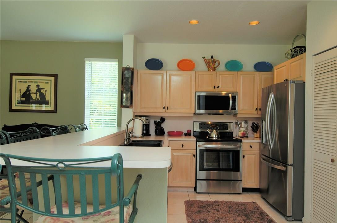 17401 Sunset Drive Southwest Ranches, FL 33331 - Photo 14 of 45 a kitchen with stainless steel appliances granite countertop a stove a refrigerator a sink a dining table and chairs with wooden floor