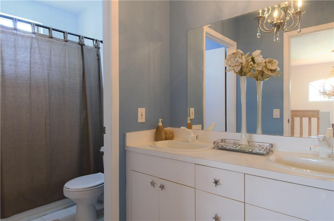 17401 Sunset Drive Southwest Ranches, FL 33331 - Photo 25 of 45 a bathroom with a granite countertop sink a toilet and a mirror