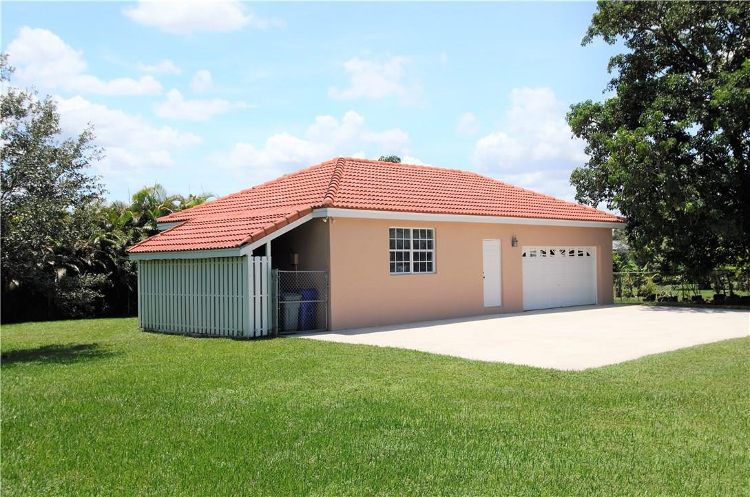 17401 Sunset Drive Southwest Ranches, FL 33331 - Photo 39 of 45 a front view of a house with a garden and yard