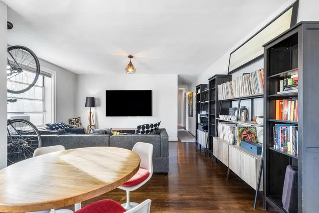 a living room with furniture a flat screen tv and a book shelf