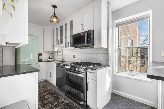 a kitchen with stainless steel appliances granite countertop a stove sink microwave and cabinets