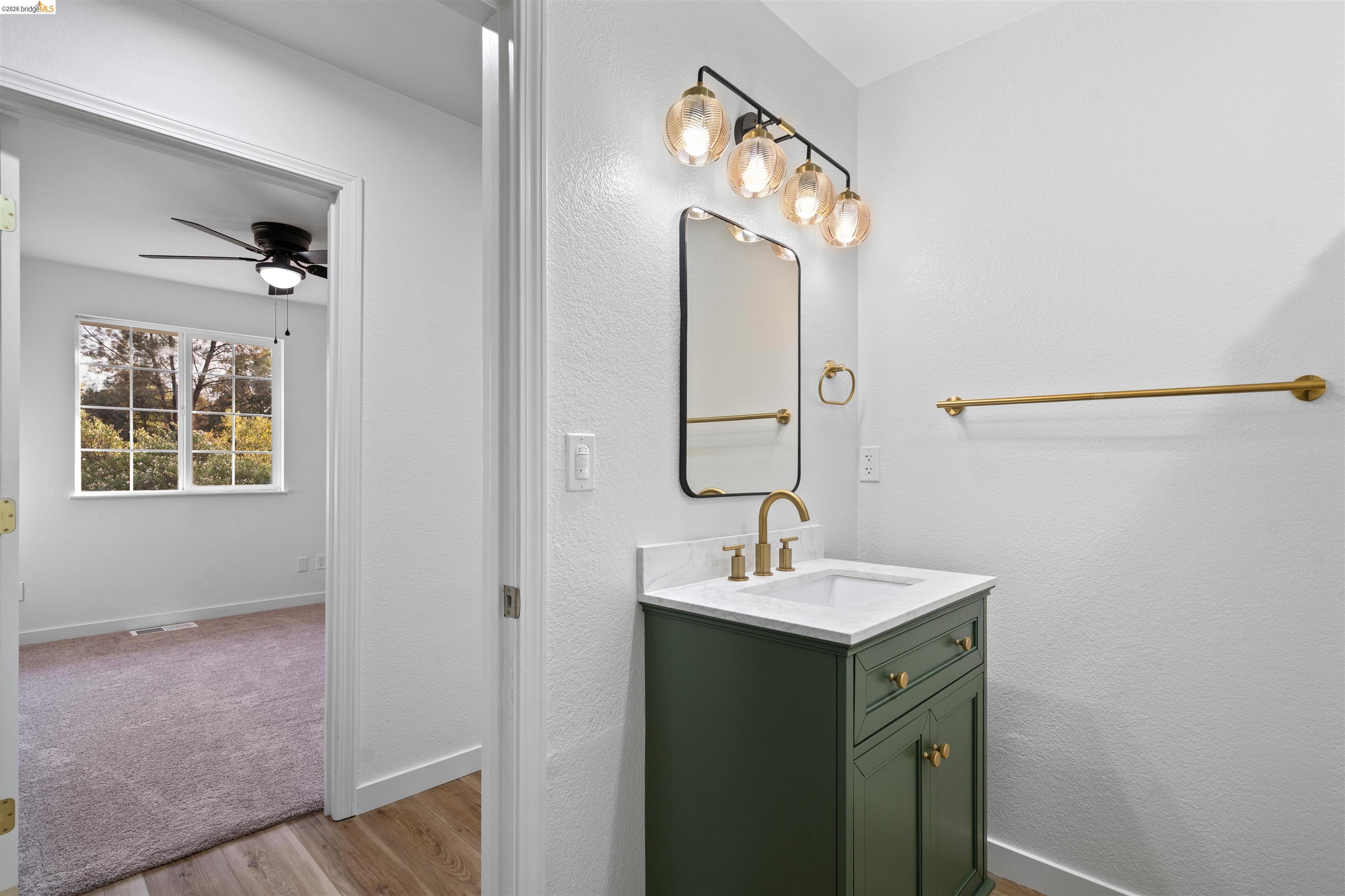 19676 Rawhide Road Sonora, CA 95370 - Photo 23 of 67 Bathroom vanity with a white countertop, undermount sink, and brass-finish faucet