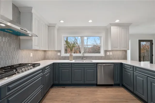 a large kitchen with stainless steel appliances granite countertop a stove a sink and a refrigerator