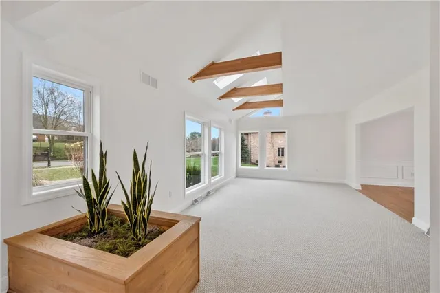 a view of empty room with wooden floor and windows