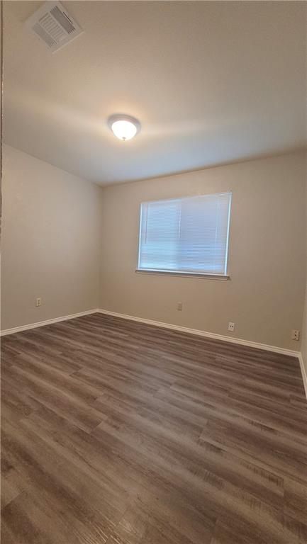 15405 Spring Hill Lane, Unit B Pflugerville, TX 78660 - Photo 13 of 18 wooden floor in an empty room with a window