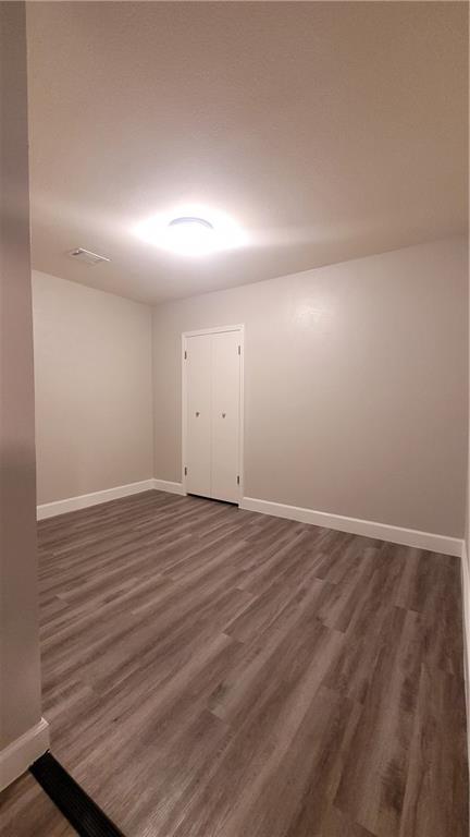 15405 Spring Hill Lane, Unit B Pflugerville, TX 78660 - Photo 16 of 18 an empty room with wooden floor and windows