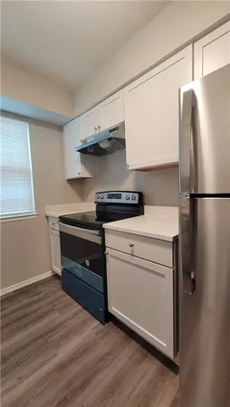 a kitchen with stainless steel appliances a refrigerator and cabinets