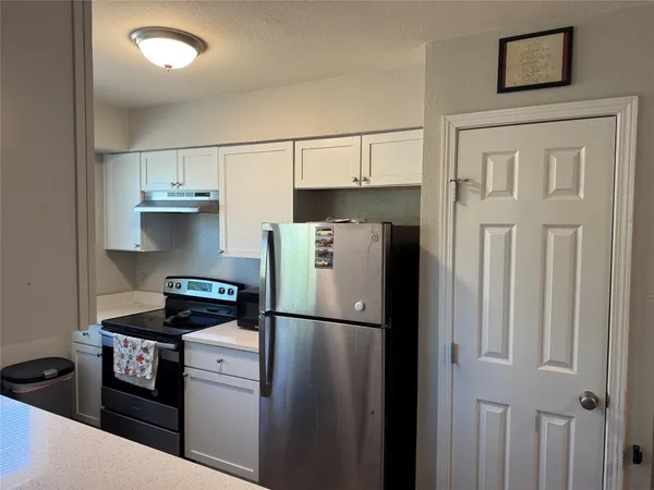 a kitchen with stainless steel appliances granite countertop a refrigerator sink and stove