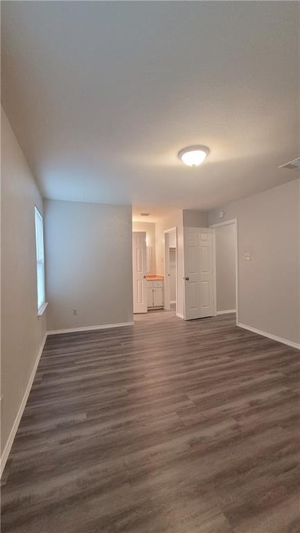 15405 Spring Hill Lane, Unit B Pflugerville, TX 78660 - Photo 9 of 18 a view of an empty room with wooden floor and window