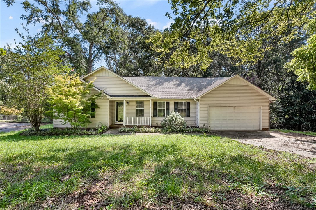 This charming home offers a welcoming facade with a garage and inviting porch.