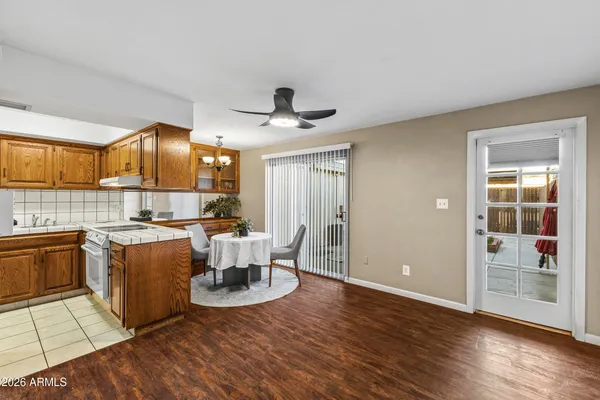 a view of kitchen with stainless steel appliances granite countertop a stove and a view of living room