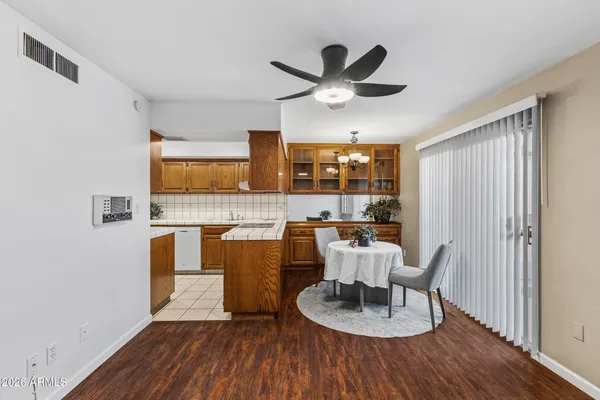 a living room with stainless steel appliances granite countertop furniture wooden floor and a kitchen view