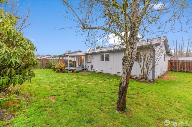 a white house that has tree in front of it